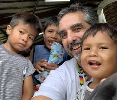 Voluntário do Ações do Bem reunido com crianças da comunidade.