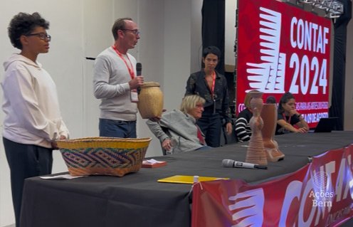 Apresentação no palco do CONTAF 2024 com peças artesanais de cerâmica e cestaria expostas sobre a mesa